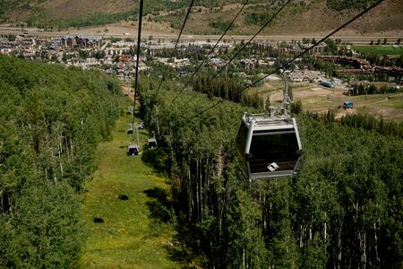 Vail, Colorado, USA - September 1, 2018 - Cable gondolas going up and down the mountain from Gondola One Station.のeditorial素材