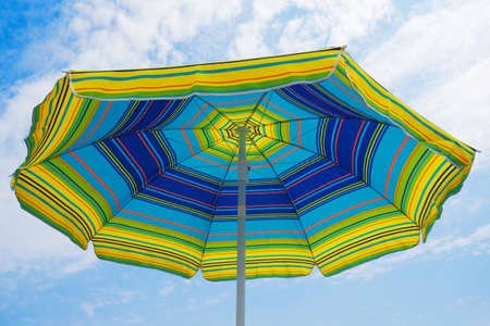 umbrella in the foreground with the sky and clouds background