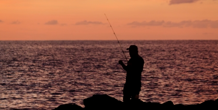 Silhouette of a man fishingの写真素材