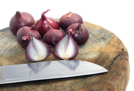 Sliced shallots on wooden cutting board isolated on whiteの写真素材