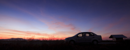 Silhouette of a car at sunsetの写真素材