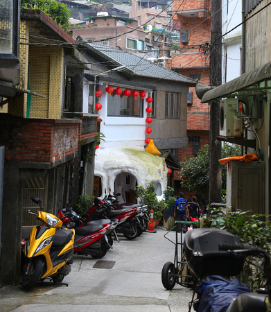 Jiufen, North Taiwan - June 6 2017 : Homes, buildings, shops and streets of Jiufen district shows scooters as their main mode of transport.のeditorial素材