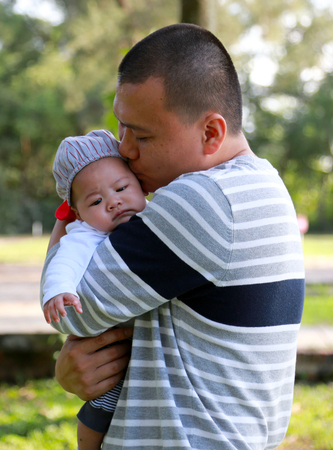 A happy father holding his newborn son with loveの写真素材