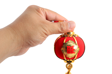 Hand holding a red spherical shape lantern for Chinese New year decoration isolated on whiteの写真素材