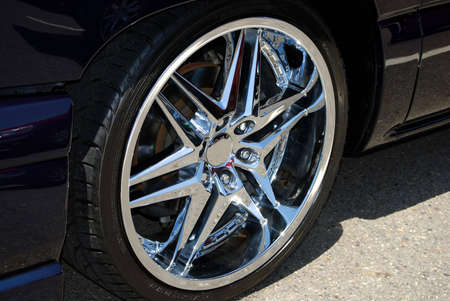 A shiny chrome wheel on a black car.
