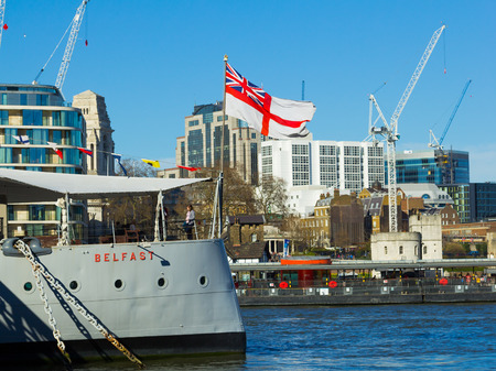 LONDON, UK - 16TH MARCH 2014  Part of the HMS Belfast Ship on the River Thames with people on the ship and the english flagsのeditorial素材