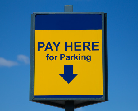 Pay Here for Parking sign with buildings in the backgroundの写真素材
