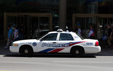TORONTO, CANADA - JUNE 1ST, 2014: A Toronto Police car parked on a street with people walking past in the backgroundのeditorial素材