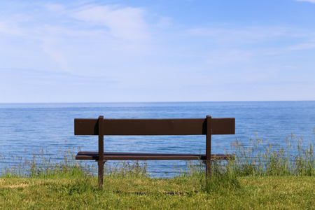 Empty Park Bench facing the oceanの写真素材