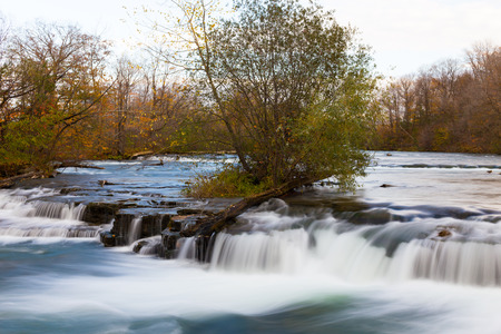 Fast flowing stream with a tree on an islandの写真素材