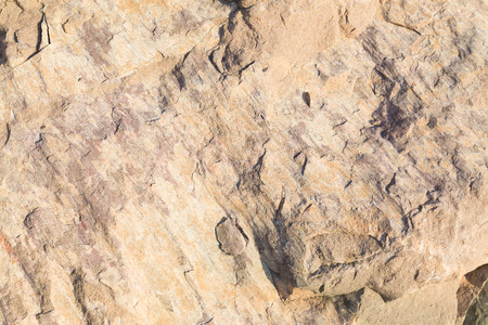 A closeup to a hard stone background with bumps and different shadesの写真素材