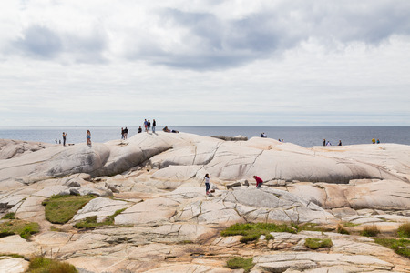 PEGGYS COVE, CANADA - 23RD AUGUST 2014: People standing on rocks near Peggys Cove Lighthouse during the dayのeditorial素材