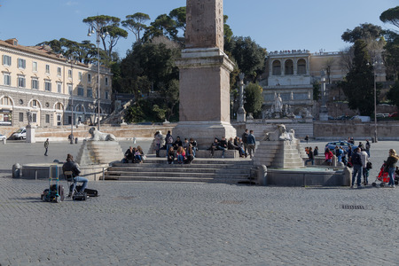 ROME, ITALY - 12TH MARCH 2015: People at the Piazza del Popolo in central Rome. A busker can be seen sitting in front of people with an instrumentのeditorial素材