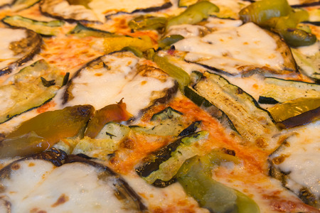 A closeup to vegetarian pizza toppings. Zucchini, green peppers and cheese can be seen.の写真素材