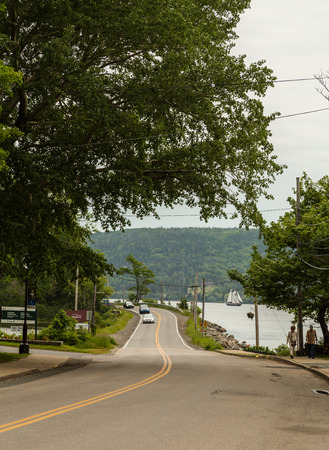 BADDECK, CANADA - 5TH JULY 2015: Roads in Baddeck, Nova Scotia, with people, cars and a boat in the distanceのeditorial素材