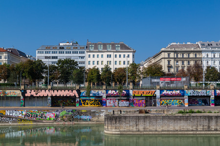 VIENNA, AUSTRIA - 8TH AUGUST 2015: Buildings along the Danube Canal during the day. People and graffiti can be seenのeditorial素材