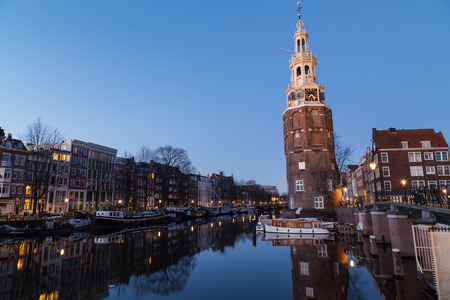 A view along the Oudeschans Canal towards the Montelbaanstoren Tower in Amsterdam at twilight.の写真素材
