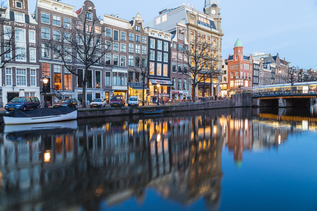 AMSTERDAM, NETHERLANDS - 16TH FEBRUARY 2016: A view along the Amsterdam Canals at twilight. Buildings, people, bridges and boats can be seen.のeditorial素材