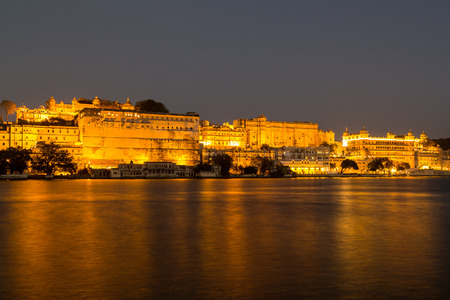 UDAIPUR, INDIA - 20TH MARCH 2016: A view towards the City Palace from Pichola Lake in Udaipur at night. Lights can be seen on the building.のeditorial素材