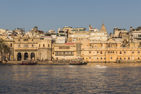 UDAIPUR, INDIA - 20TH MARCH 2016: A view of part of the City of Udaipur at the lake waterfront during the day close to sunset. People and boats can be seen.のeditorial素材