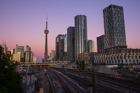 TORONTO, CANADA - 8TH OCTOBER 2013: Part of downtown Toronto at sunset. Condominium, the CN Tower, office buildings and train tracks can be seen.のeditorial素材