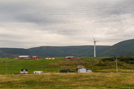 CAPE BRETON, CANADA - 27TH AUGUST 2014: Buildings, hills and a wind turbine in Cape Breton, Nova Scotia during the dayのeditorial素材