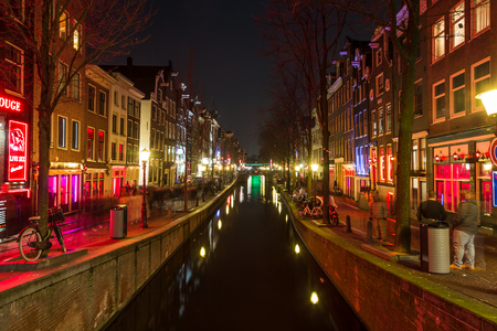 AMSTERDAM, NETHERLANDS - 17TH FEBRUARY 2016: A view along the Oudezijds Achterburgwal Canal in the De Wallen District in Amsterdam at night.のeditorial素材