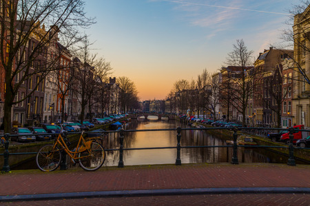 AMSTERDAM, NETHERLANDS - 17TH FEBRUARY 2016: Bikes, buildings and boats along the canals in Amsterdam at dawn.のeditorial素材