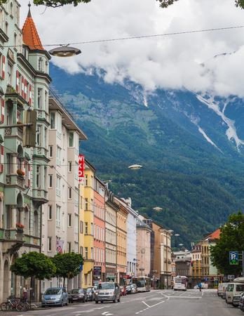 INNSBRUCK, AUSTRIA - 18TH JUNE 2016: A view of streets, buildings and mountains in Innsbruck during the day. People can be seen.のeditorial素材