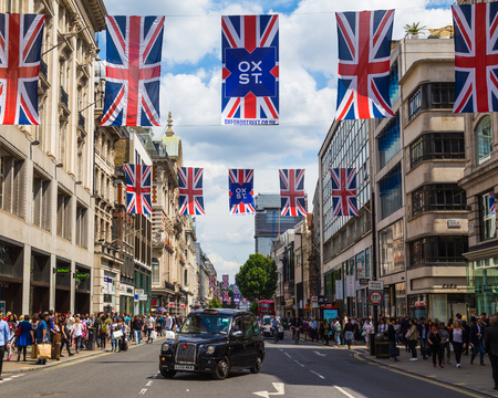 LONDON, UK - 28TH JUNE 2016: A view along Oxford Street in London during the day. A black London taxi, union jack flags and lots of people can be seen.のeditorial素材