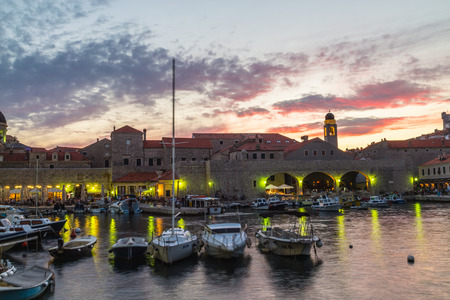 DUBROVNIK, CROATIA - 11TH AUGUST 2016: Boats docked in the Dubrovnik Old Port at sunset. People can be seen.のeditorial素材