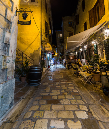 KOTOR, MONTENEGRO - 13TH AUGUST 2016: A view along streets of Kotor at night. The outside of shops, restaurants and people can be seen.のeditorial素材