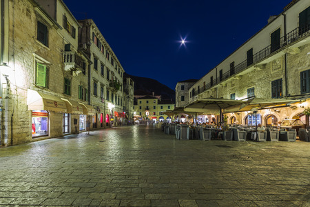 KOTOR, MONTENEGRO - 13TH AUGUST 2016: Views along streets of Old Town Kotor at night. The outside of buildings, restaurants and people can be seen.のeditorial素材