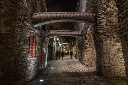 TALLINN, ESTONIA - 3RD JAN 2017:  A view along St. Catherine's Passage in Tallinn at night. People can be seen in the distance.のeditorial素材