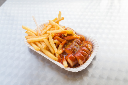 Closeup to Currywurst serving with fries and spicy sauce, a traditional german dish.の写真素材