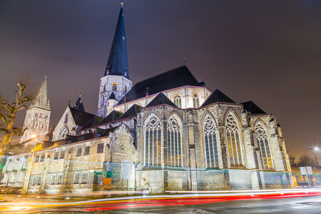 GHENT, BELGIUM - 18TH FEBRUARY 2016: The outside of St. James' Church, Antwerp (Sint-Jacobskerk) in Ghent at Night. The trails of traffic can be seen going round a roundabout nearby.のeditorial素材