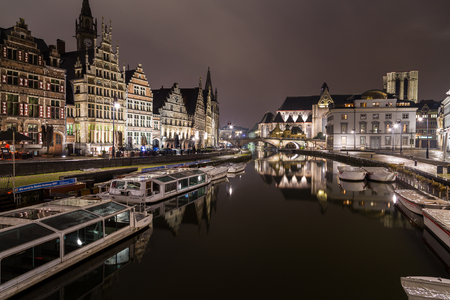 GHENT, BELGIUM - 18TH FEB 2016: A view towards Sint-Michielskerk (Saint Michael's Church, Ghent) in Ghent at night from the Graslei and Korenlei. Boats and other buildings can be seen.のeditorial素材