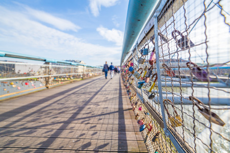 KRAKOW, POLAND -  15TH OCTOBER 2016: Kladka Ojca Bernatka Bridge in Krakow seen with padlocks attached to it which is normally a sign of love. People can be seen in the distance.のeditorial素材