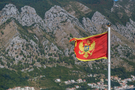 The national flag of Montenegro with part of the landscape in the background.の写真素材