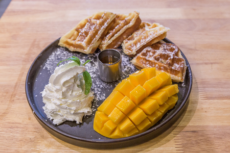 Mango Waffles, cream and syrup breakfast at a restaurantの写真素材