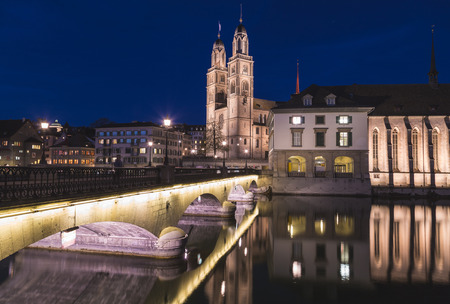 ZURICH, SWITZERLAND - 17TH APRIL 2018: The GrossmÃ¼nster Church in Zurich from across the Limmat River at night.のeditorial素材