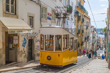 LISBON, PORTUGAL - 10TH AUGUST 2019: The Elevador da Bica in central Lisbon showing the iconic yellow tram and surrounding buildings. People can also be seen.のeditorial素材