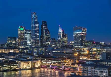 Office buildings in the City of London at night. The outside of tall skyscrapers can be seen.の写真素材