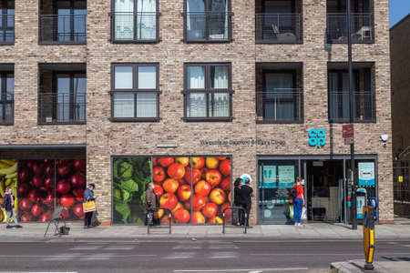 LONDON, UK - 9TH APRIL 2020: Social distancing controls outside a Co-op store in London. Designed to try and protect against the spread of Coronavirus (Covid-19). Queues and people can be seen.のeditorial素材