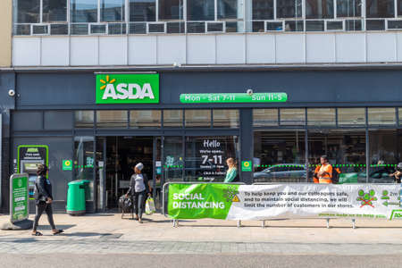 LONDON, UK - 9TH APRIL 2020: Social distancing controls outside an Asda store in London. Designed to try and protect against the spread of Coronavirus (Covid-19). Queues and people can be seen.のeditorial素材