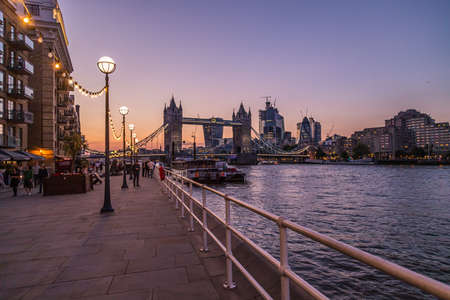LONDON, UK - 1ST SEPT 2018: Views along the banks of the River Thames towards Tower Bridge and the City of London in the early evening. People can be seen on the pathのeditorial素材