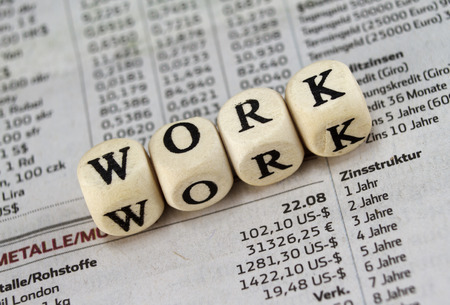 Work word built with letter cubes on newspaper background Work word built with letter cubes on newspaper background