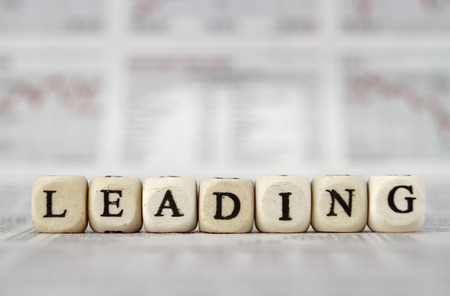 Leading word built with letter cubes on newspaper backgroundの写真素材