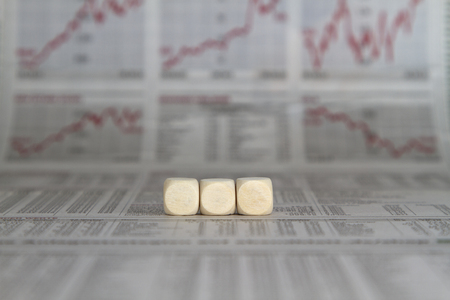 a row of three blank cubes on a business newspaper backgroundの写真素材