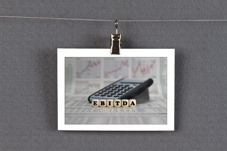EBITDA word built with letter cubes on newspaper background on pinboardの写真素材
